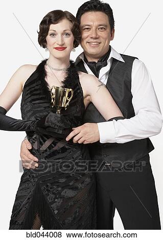 Multi-ethnic couple holding tango trophy View Large Photo Image Stock Photo - Multi-ethnic couple holding tango trophy. Fotosearch