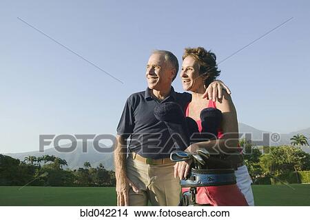 Picture - Multi-ethnic couple on golf course. Fotosearch