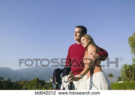 Stock Image - Multi-ethnic couple on golf course. Fotosearch