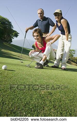 Stock Photography - Multi-ethnic friends playing golf. Fotosearch