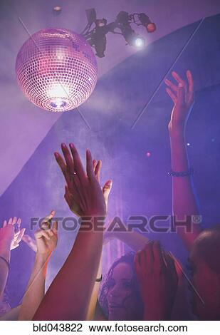 Stock Image - Multi-ethnic people dancing at nightclub. Fotosearch