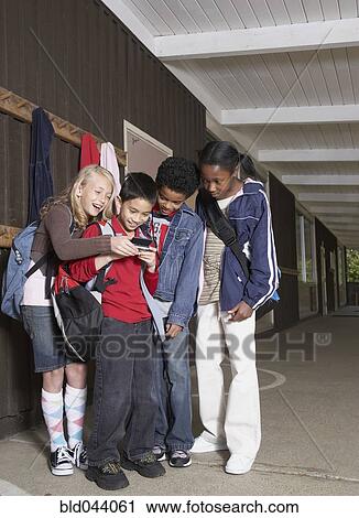 Multi-ethnic school children looking at cell phone View Large Photo Image Stock Image - Multi-ethnic school children looking at cell phone. Fotosearch