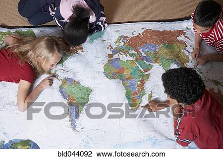 Multi-ethnic students looking at world map View Large Photo Image Stock Image - Multi-ethnic students looking at world map. Fotosearch