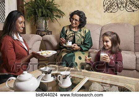 Multi-generational Indian female family members having snack View Large Photo Image Picture - Multi-generational Indian female family members having snack. Fotosearch