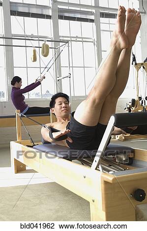 Stock Image - People stretching in exercise studio. Fotosearch