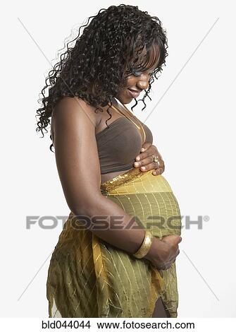 Picture - Pregnant African American woman with hands on belly. Fotosearch