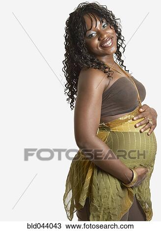 Stock Image - Pregnant African American woman with hands on belly. Fotosearch