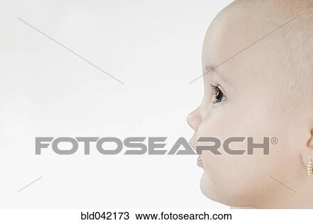 Stock Image - Profile of Hispanic baby with earring. Fotosearch