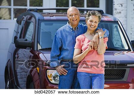 Stock Photo - Senior African American couple leaning on car. Fotosearch