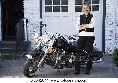 Senior African American woman next to motorcycle View Large Photo Image Picture - Senior African American woman next to motorcycle. Fotosearch