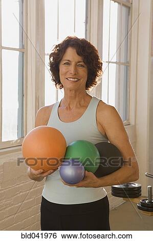 Senior woman holding exercise balls View Large Photo Image Stock Photograph - Senior woman holding exercise balls. Fotosearch