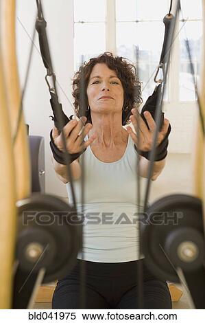 Senior woman stretching on exercise equipment View Large Photo Image Stock Photography - Senior woman stretching on exercise equipment. Fotosearch