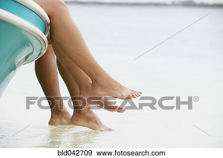 Stock Photo - South American couple dangling feet off of boat. Fotosearch