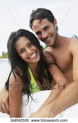 Stock Photography - South American couple hugging at beach. Fotosearch