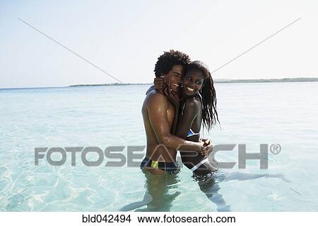 Picture - South American couple hugging in water. Fotosearch