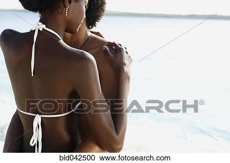 Stock Image - South American couple hugging in water. Fotosearch