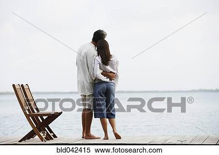 Stock Photography - South American couple hugging on dock. Fotosearch