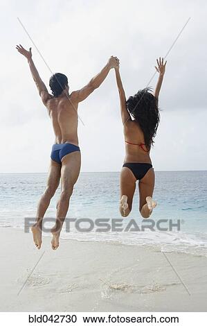 South American couple jumping at beach View Large Photo Image Stock Image - South American couple jumping at beach. Fotosearch