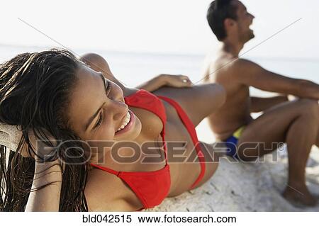 Stock Photography - South American couple laying on beach. Fotosearch