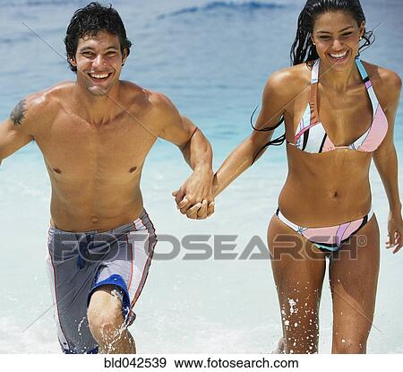 South American couple running in water View Large Photo Image Stock Photo - South American couple running in water. Fotosearch