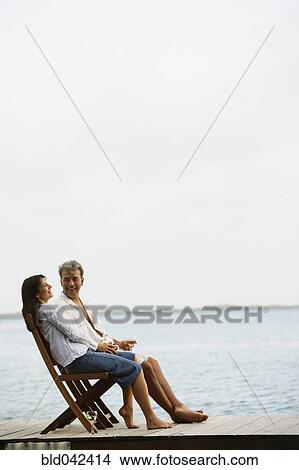South American couple sitting on dock View Large Photo Image Picture - South American couple sitting on dock. Fotosearch