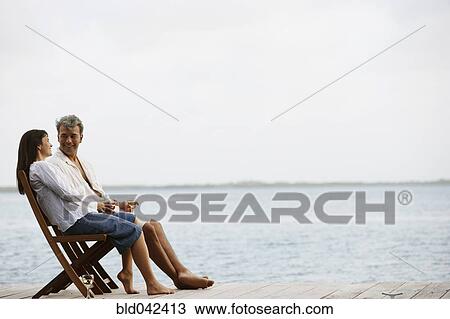 South American couple sitting on dock View Large Photo Image Stock Image - South American couple sitting on dock. Fotosearch
