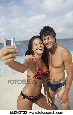 Stock Image - South American couple taking own photograph. Fotosearch