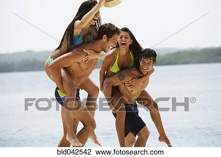 Stock Image - South American couples playing at beach. Fotosearch