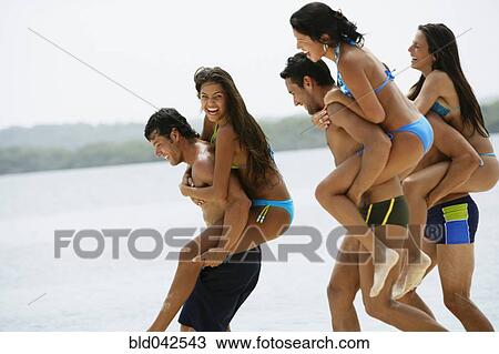 Stock Image - South American couples playing at beach. Fotosearch