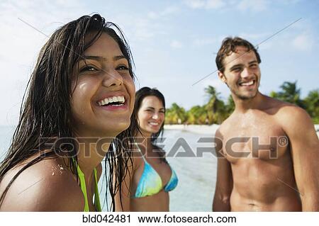 Stock Image - South American friends at beach. Fotosearch