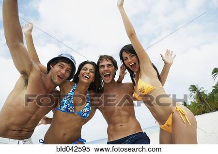 Stock Photography - South American friends cheering at beach. Fotosearch