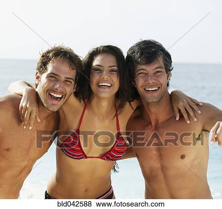 Stock Photo - South American friends hugging at beach. Fotosearch