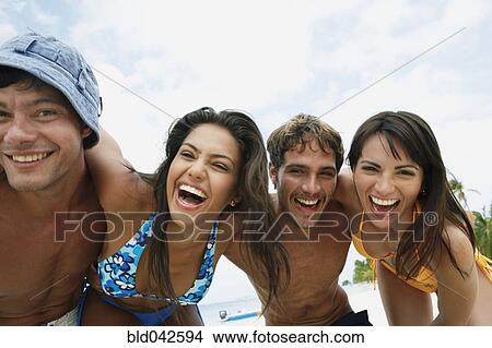 Picture - South American friends laughing at beach. Fotosearch