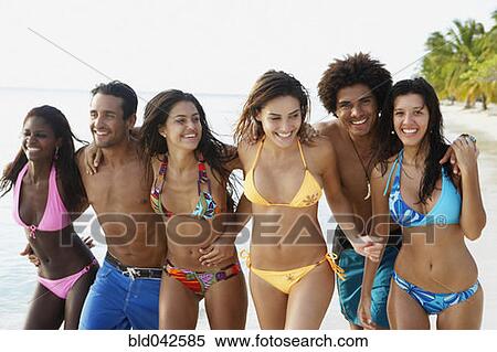 Stock Photography - South American friends walking on beach. Fotosearch