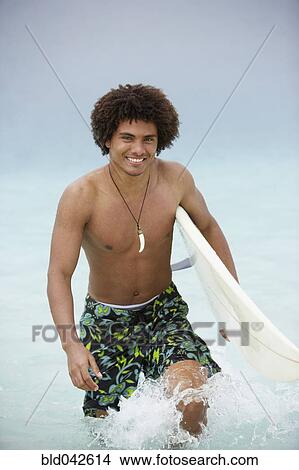 South American man carrying surfboard View Large Photo Image Picture - South American man carrying surfboard. Fotosearch