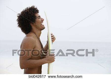 South American man holding surfboard View Large Photo Image Stock Photo - South American man holding surfboard. Fotosearch