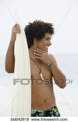 South American man holding surfboard View Large Photo Image Stock Photo - South American man holding surfboard. Fotosearch