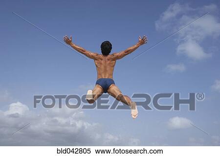 Stock Photography - South American man in bathing suit jumping. Fotosearch