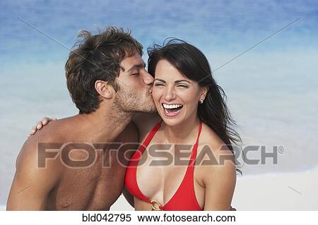 Stock Photography - South American man kissing girlfriend's cheek. Fotosearch