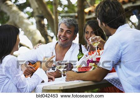 Stock Image - South American man playing guitar for friends. Fotosearch
