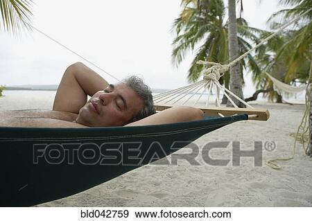 Stock Photo - South American man sleeping in hammock. Fotosearch