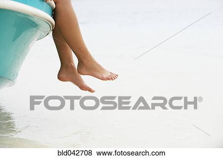 Stock Photo - South American woman dangling feet off of boat. Fotosearch
