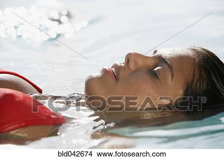 Picture - South American woman floating in water. Fotosearch