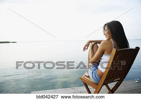 Stock Photo - South American woman in deck chair on dock. Fotosearch
