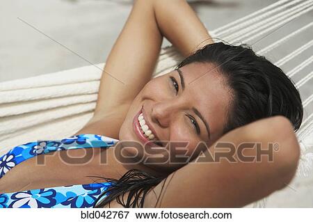 Stock Photo - South American woman laying in hammock. Fotosearch