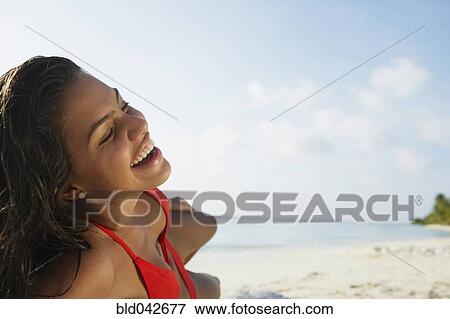 Stock Photo - South American woman laying on beach. Fotosearch