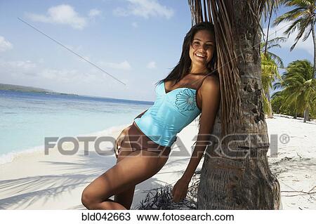 South American woman leaning on palm tree View Large Photo Image Stock Image - South American woman leaning on palm tree. Fotosearch