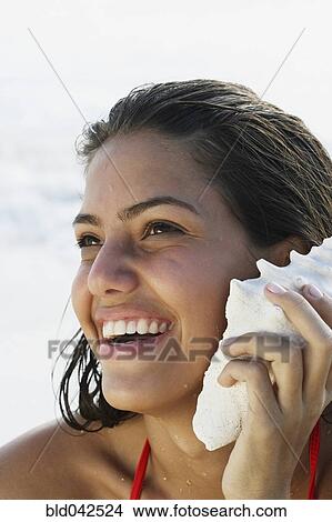 South American woman listening to seashell View Large Photo Image Picture - South American woman listening to seashell. Fotosearch