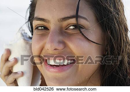South American woman listening to seashell View Large Photo Image Stock Photograph - South American woman listening to seashell. Fotosearch