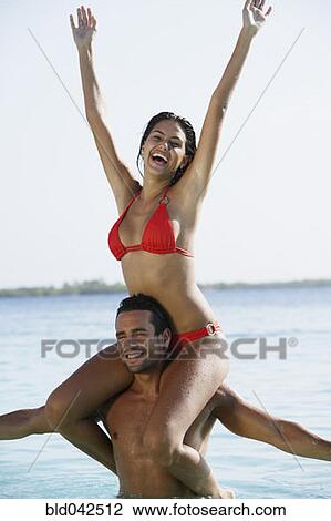 South American woman sitting on boyfriend's shoulders View Large Photo Image Stock Image - South American woman sitting on boyfriend's shoulders. Fotosearch